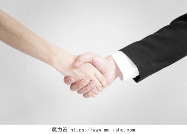 灰色背景上紧握双手男女在商业上的握手